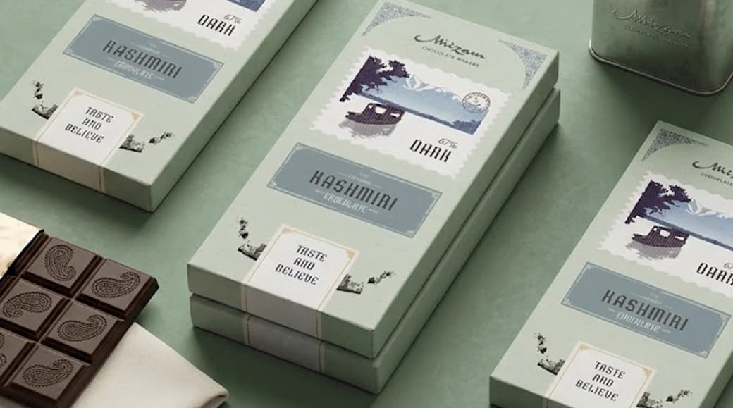 Sage-green Mirzam chocolate bars, each carrying a stamp illustration of a houseboat on a Kashmiri lake, with a paisley-embossed bar and a tin beside them.
